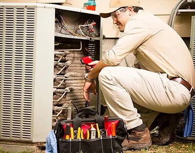 tech repairing air conditioner unit