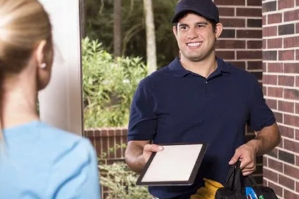 trane tech handing clipboard to home owner